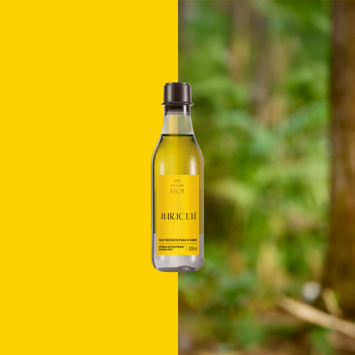 Frasco transparente de Óleo Trifásico Desodorante Corporal Ekos Maracujá com rótulo amarelo ao centro. Fundo dividido entre amarelo vibrante e floresta desfocada em tons de verde.