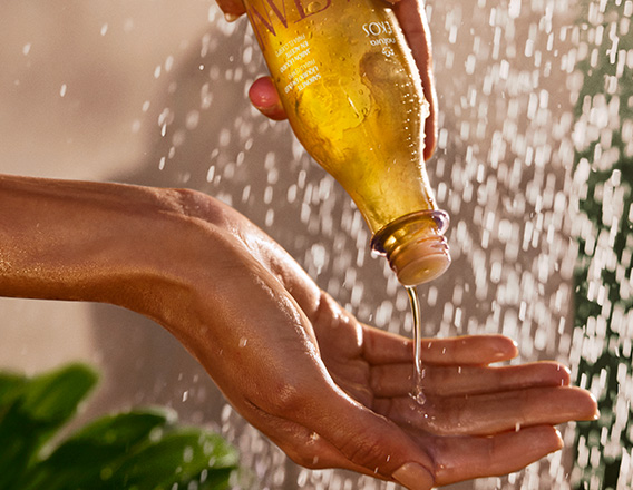 Produto Natura Ekos sendo aplicado em uma mão durante o banho.