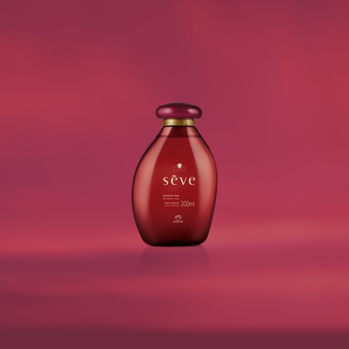 Natura Sève Óleo Desodorante Corporal Pimenta Rosa, com frasco vermelho e tampa rosa-choque, destaca-se sobre fundo rosa vibrante.