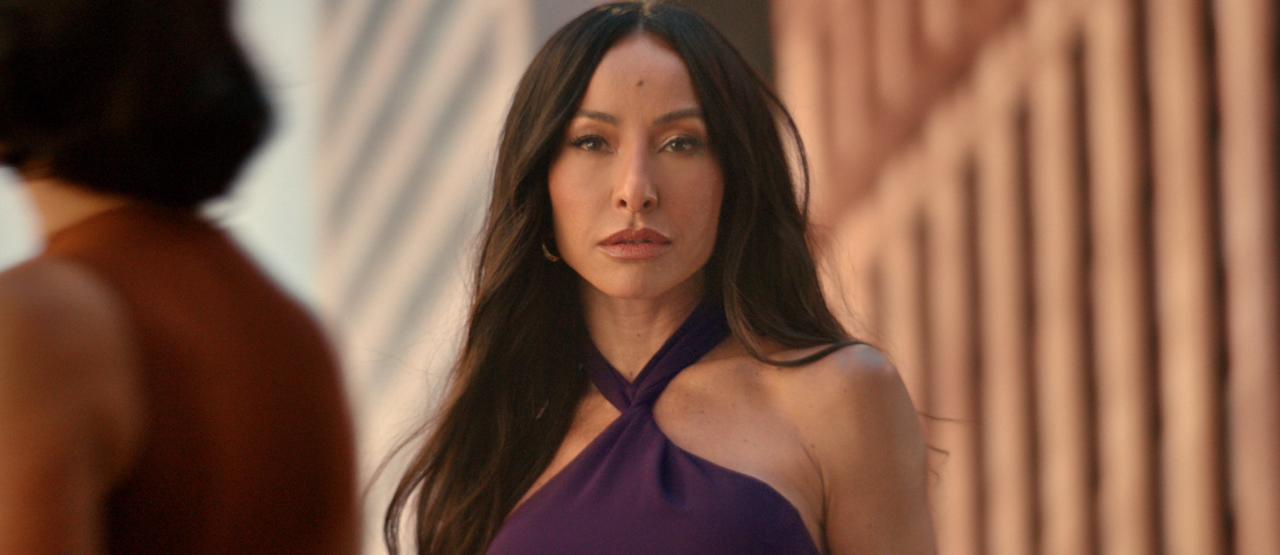 Sabrina Sato caminha com confiança em um cenário urbano ao pôr do sol, usando um vestido roxo. O vídeo alterna entre closes dela aplicando o perfume e detalhes sensoriais de flores e gotas de água, finalizando com os frascos de Luna e Luna Nuit sobre um fundo alaranjado.