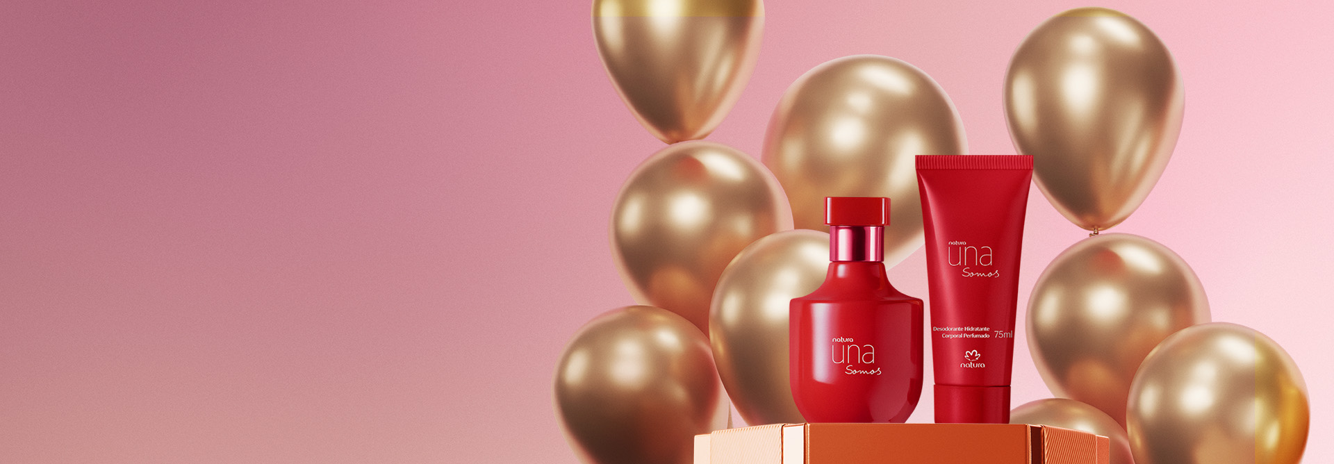 Dois frascos vermelhos da linha Una Somos, Deo Parfum e Desodorante Hidratante Corporal Perfumado, sobre caixa e balões dourados. Fundo em degradê rosa.