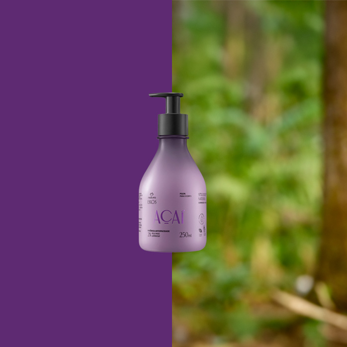 Frasco lilás do Polpa Desodorante Hidratante Corporal Ekos Açaí 250 ml com válvula preta ao centro. Fundo dividido entre roxo sólido e floresta desfocada.