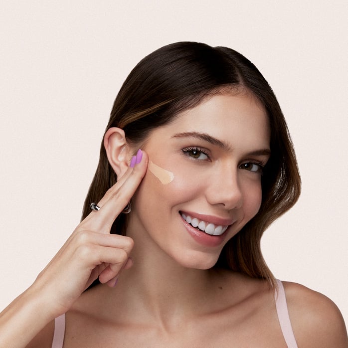 Modelo negra, com cabelo trançado, usa um delineado marcante nos olhos e batom vermelho da linha Natura Faces.