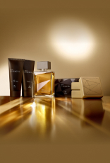 Presente Essencial Masculino com Balm Pós-barba, Creme de Barbear, Deo Parfum e três Sabonetes em Barra aparece iluminado sobre superfície dourada em fundo dourado.