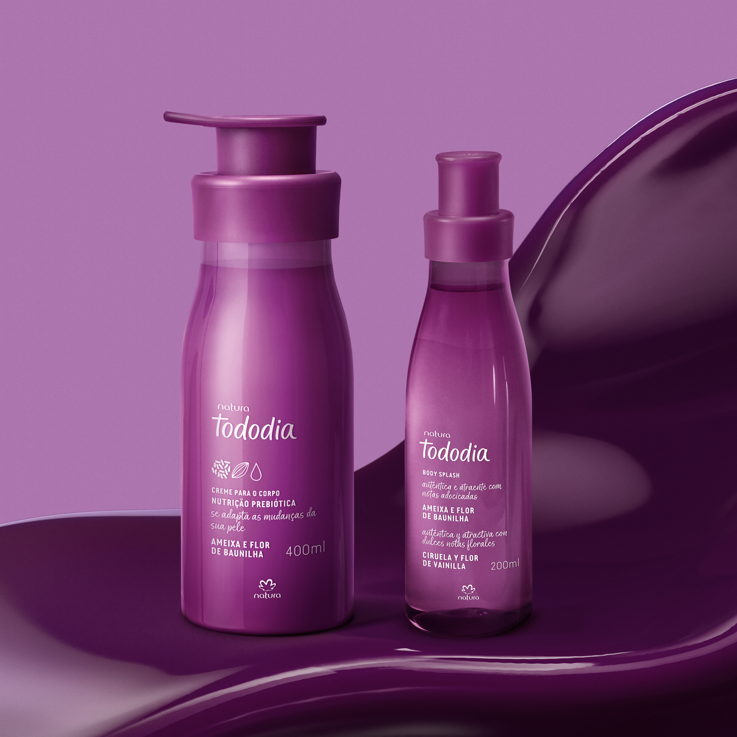 2 produtos de Tododia Ameixa e Flor de Baunilha, sendo 1 frasco de body splash e 1 frasco pump de creme, ambos com embalagens roxas, repousam sobre uma textura cremosa na cor roxo escuro.