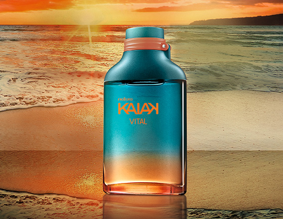 Frasco da fragrância Kaiak Vital masculino em coral com degradê turquesa. Fundo de praia com mar e pôr do sol alaranjado.