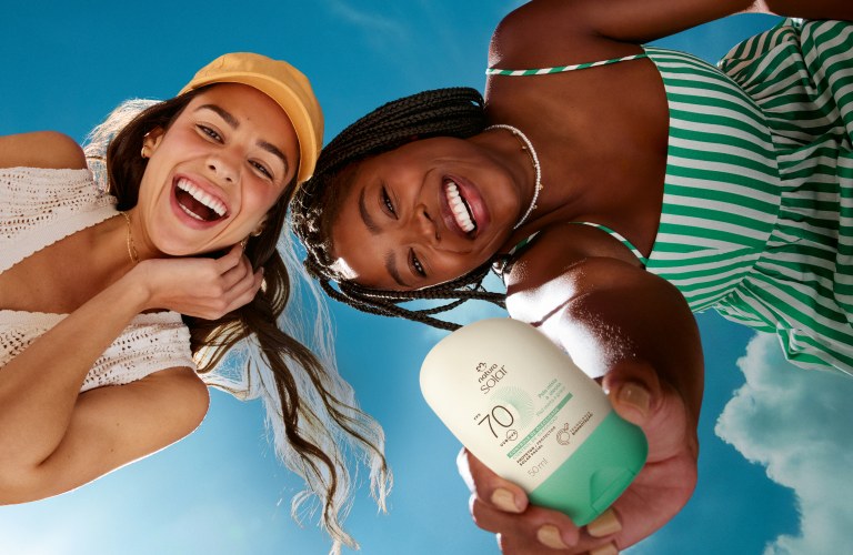 2 mulheres vistas de baixo, mostrando seu protetor solar para tomar cuidado com a pele no verão