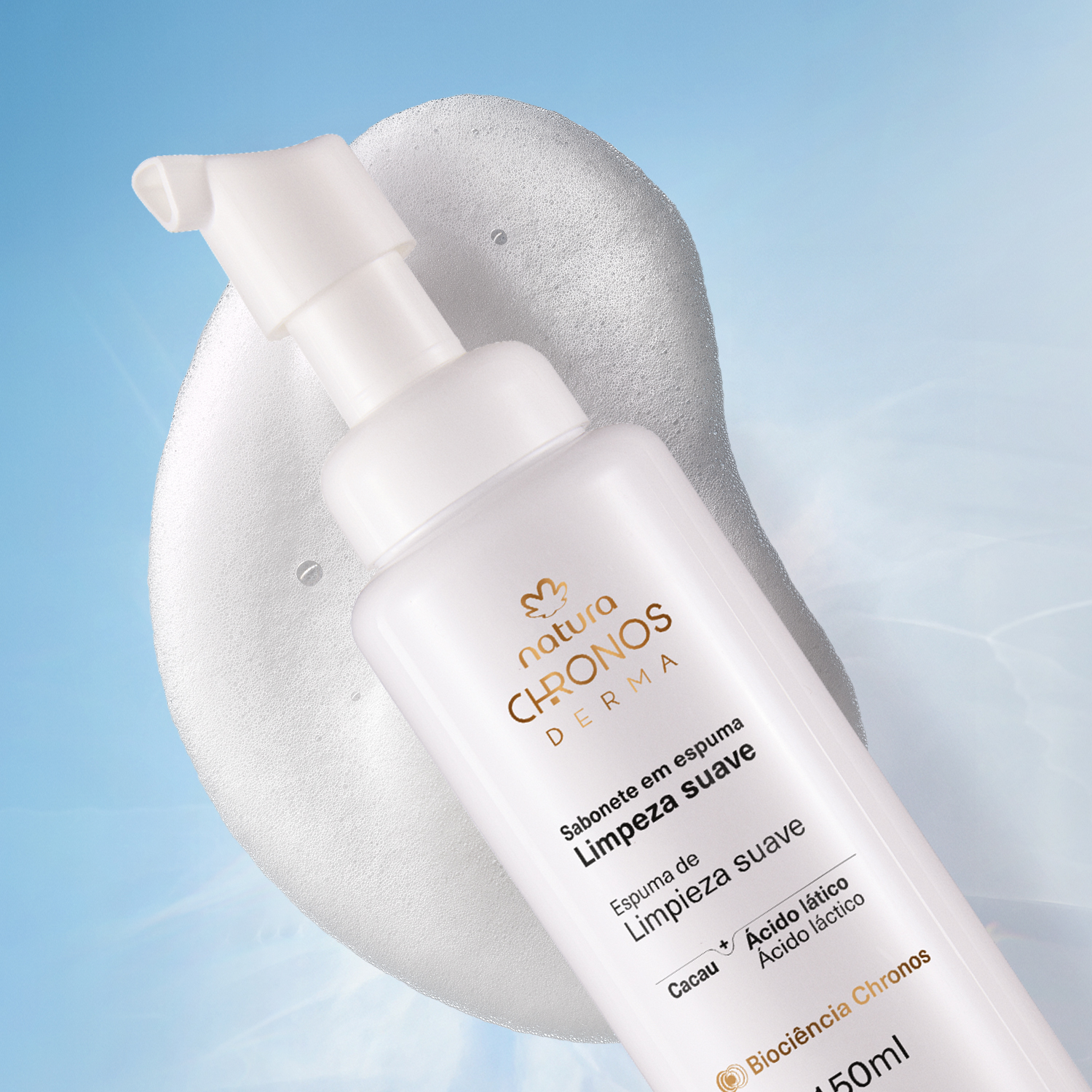 Foto com vista superior do frasco do Sabonete em Espuma Chronos Derma. O frasco está deitado sobre uma nuvem de espuma, representando a textura do produto. 