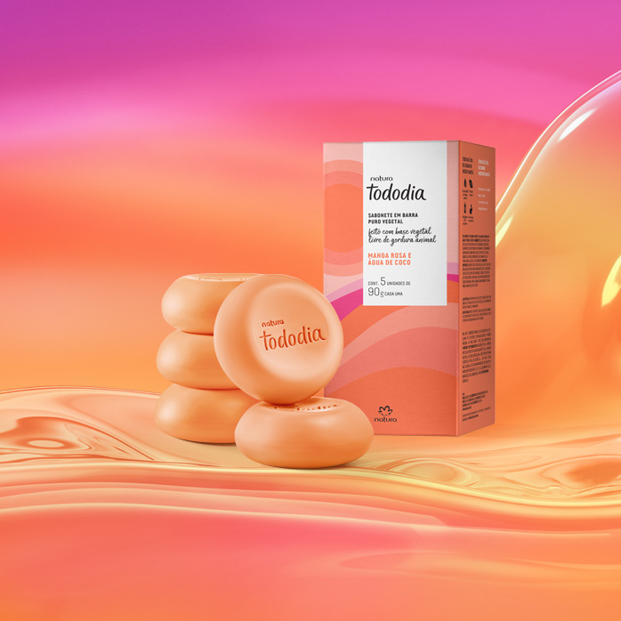 Sabonetes laranja com caixa estampada em tons alaranjados de Tododia Manga Rosa e Água de Coco sobre grafismo e fundo em laranja com rosa.