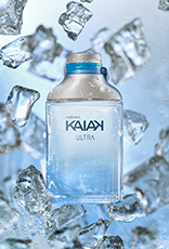 Frasco da fragrância Kaiak Ultra masculino em vidro azul degradê. Fundo com blocos de gelo flutuantes em tons de azul, em sensação refrescante.