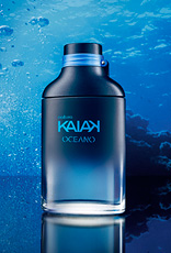 Frasco da fragrância Kaiak Oceano masculino em vidro azul. Fundo marinho com bolhas e reflexo sobre superfície brilhante.