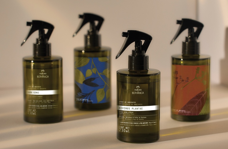 4 aromatizadores de ambiente spray dispostos em uma superfície branca. No fundo há uma parede branca