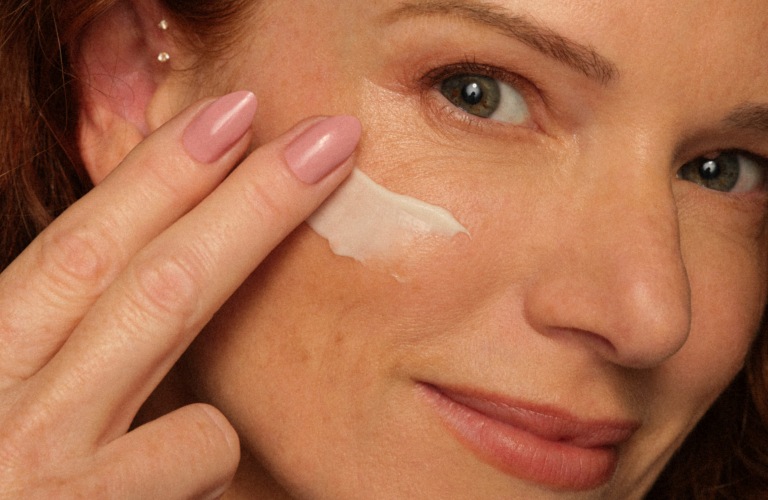 mulher passando hidratante no rosto