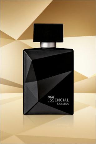 Frasco de Essencial Exclusivo Masculino, em tom de preto, aparece iluminado sobre superfície e fundo dourado-acinzentados.