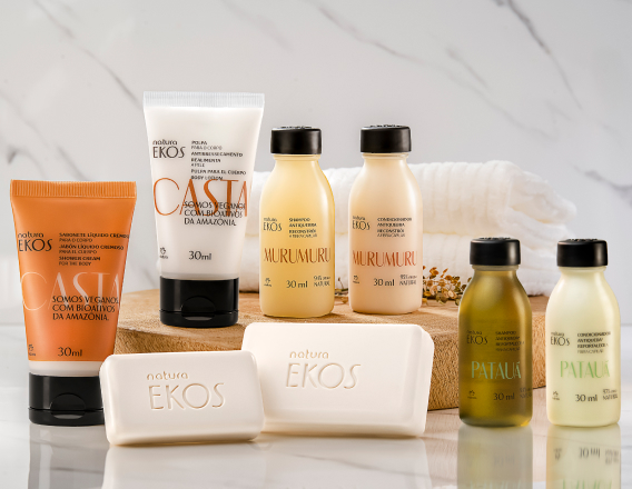 Sabonete Líquido e Polpa Tododia Castanha, Shampoo e Condicionador Murumuru, Sabonetes em Barra Ekos e Shampoo e Condicionador Ekos Patauá em superficie de pedra branca com toalha branca ao fundo.