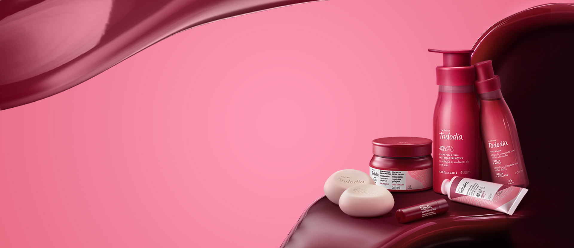 Produtos Natura Tododia Cereja e Avelã sobre formas orgânicas em vermelho, à direita, em fundo rosa.