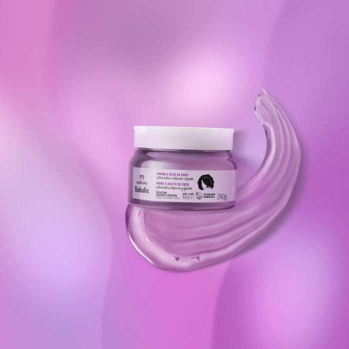 Gelatina Natura Tododia Cachos e Crespos sobre textura  transparente do produto, em fundo roxo.