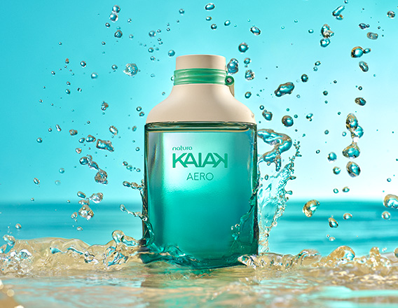Frasco da fragrância Kaiak Aero em verde-água. Fundo azul com respingos e jatos de água em movimento.