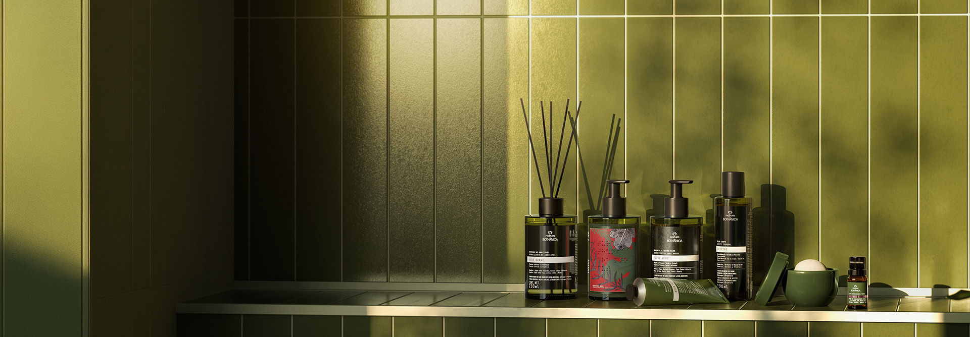 7 produtos de Natura Botânica, incluindo difusores de ambientes, óleo essencial e produtos para o corpo. Embalagens verde-escuras com tampas pretas em um banheiro de azulejos verdes.