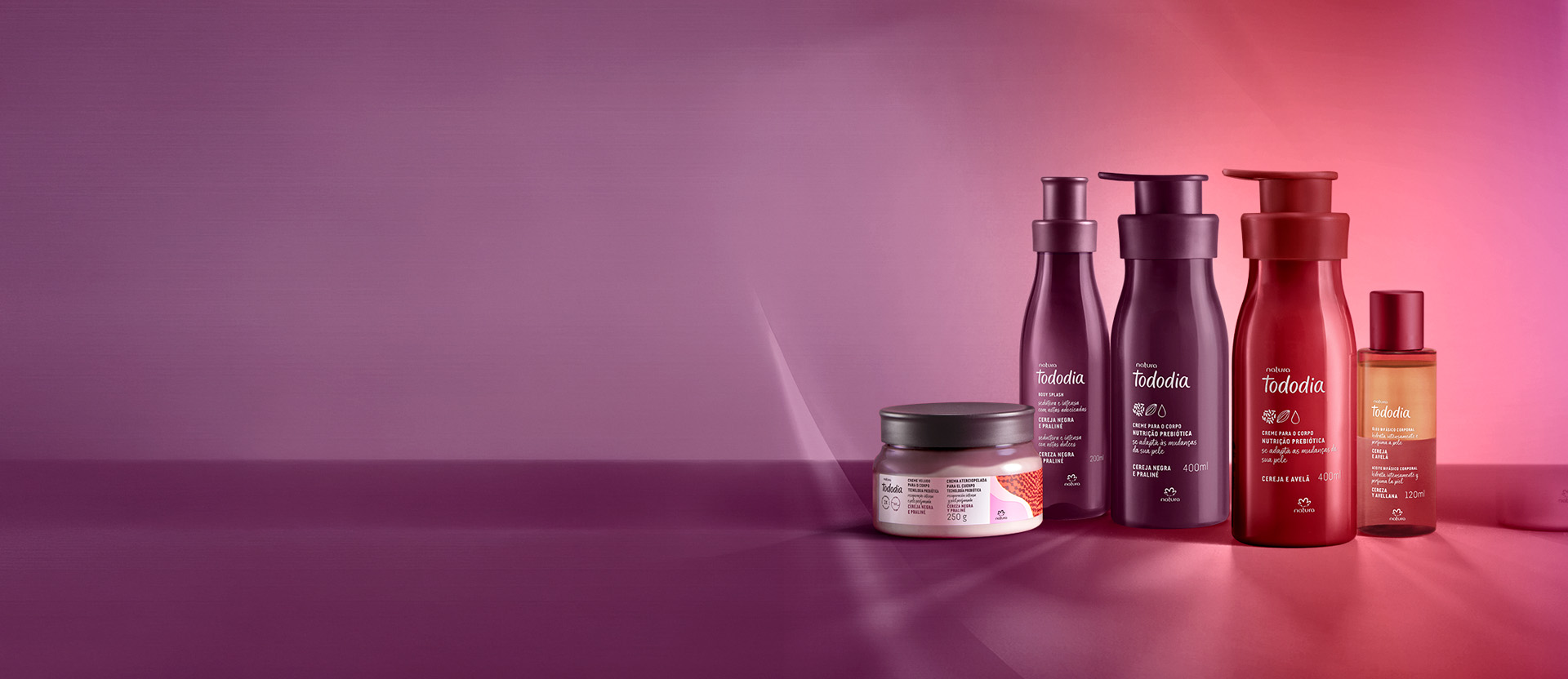 1 Creme Amanteigado Corporal Perfumado, 1 Body Splash e 1 Creme Nutritivo para o Corpo Tododia Cereja Negra e Praliné ao lado de 1 Creme Nutritivo para o Corpo e 1 Óleo Bifásico Tododia Cereja e Avelã.