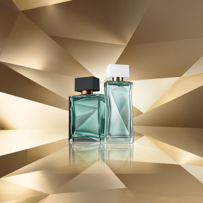 Essencial Sentir Masculino e Feminino, com frascos em tons de verde-água, aparecem em destaque sobre fundo dourado multifacetado, que faz alusão ao design dos frascos de Essencial.