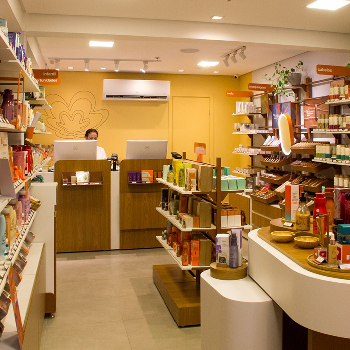 Foto do ambiente de uma loja Natura, com produtos e bancadas de experimentação.