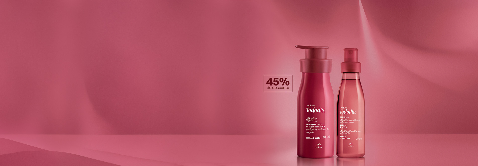 Creme Nutritivo para o Corpo e Body Splash Tododia Cereja e Avelã, com frascos rosa-escuros, destacam-se no centro da tela sobre fundo rosa com selo retangular escrito 45% de desconto.