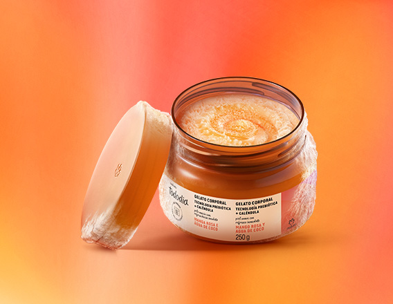 Pote laranja aberto de Gelato Corporal Tododia Manga Rosa e Água de Coco sobre fundo em tons alaranjados. O item tem conteúdo laranja com textura congelada, assim como sua base e tampa.