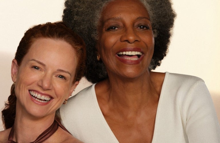 2 mulheres sorrindo de pé