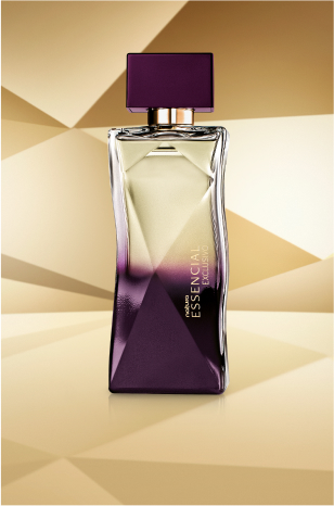 Frasco de Essencial Exclusivo Feminino, com topo transparente e base roxa, aparece em destaque no centro da tela sobre fundo multifacetado dourado, fazendo alusão ao design do frasco de Essencial.