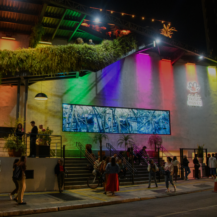 Imagem com a fachada iluminada da Casa Natura Musical à noite, com a frase "casa natura musical" em destaque sobreposta