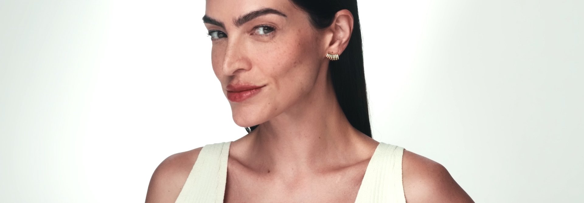 Sabonete em Pó Enzimático Limpeza Uniformizadora, Multiprotetor Clareador FPS 70 e Sérum Intensivo Multiclareador envoltos por esfera translúcida roxa, em fundo branco com selo Aprovado por Dermatologistas. 