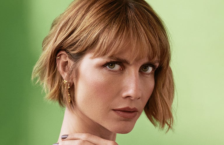 Mulher com cabelo curto e usando um tipo de franja que cobre toda sua testa