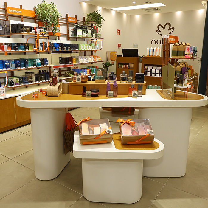 Foto de uma bancada de exposição e experimentação de produtos em uma loja Natura.