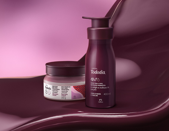 Produtos da linha Natura Tododia Cereja Negra e Praliné sobre forma orgânica na cor vinho e fundo em tons de rosa.