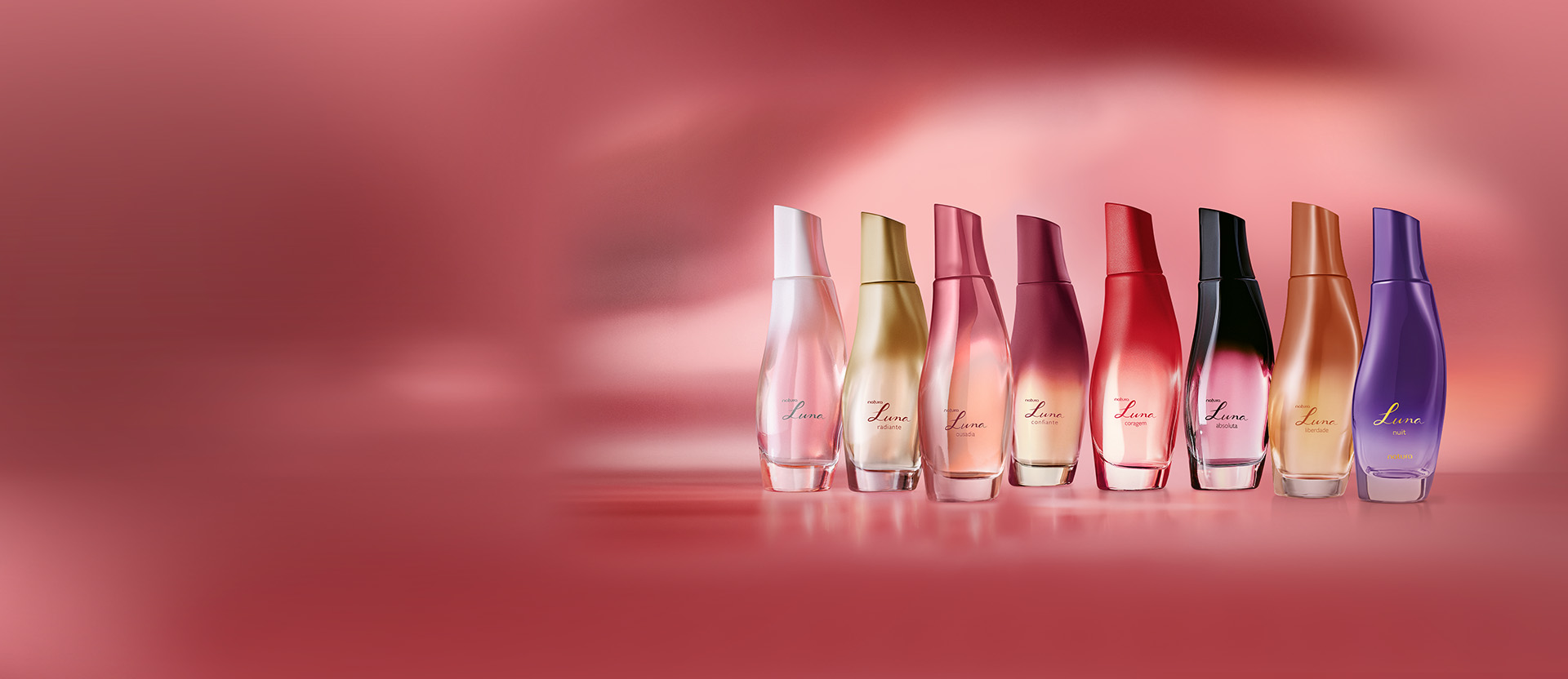 8 frascos degradê coloridos do Desodorante Colônia com fragrâncias Luna, Luna Radiante, Ousadia, Confiante, Coragem, Absoluta, Liberdade e Nuit. Frascos alinhados sobre fundo degradê rosa.