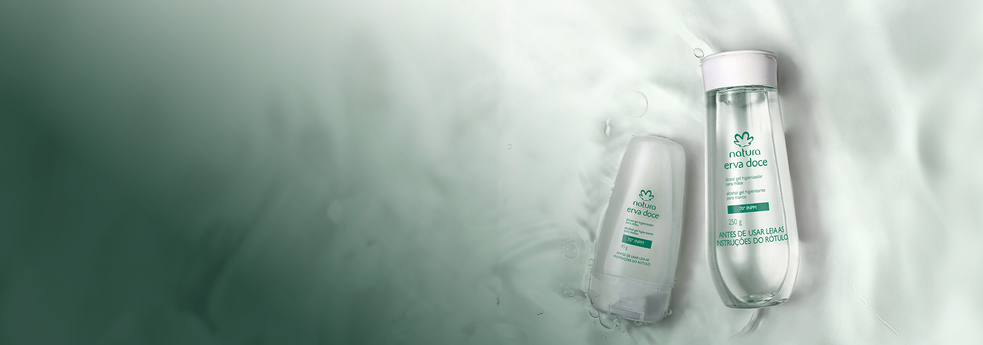 Dois frascos de álcool gel higienizador de Natura Erva Doce imersos em água cristalina, transmitindo frescor e delicadeza.