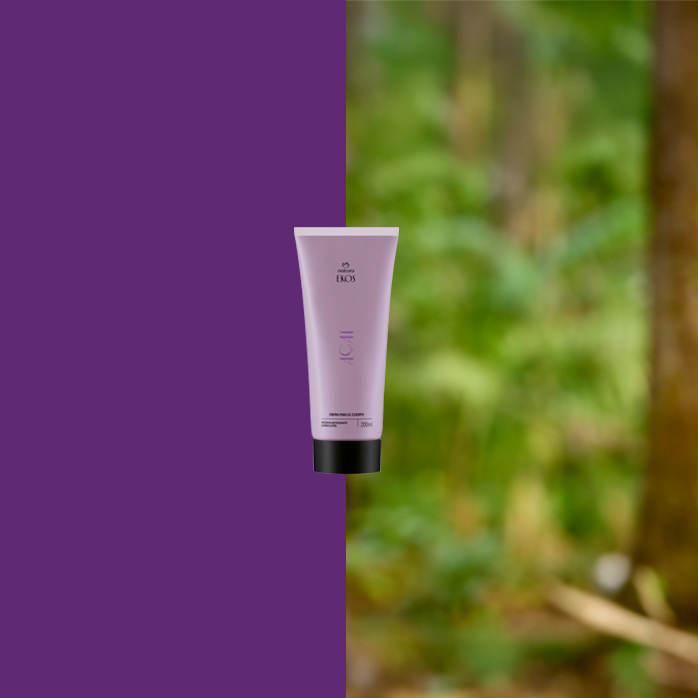 Bisnaga lilás do Ekos Açaí com tampa preta está centralizada, dividindo o fundo entre roxo sólido à esquerda e floresta desfocada à direita, sugerindo conexão com a natureza.