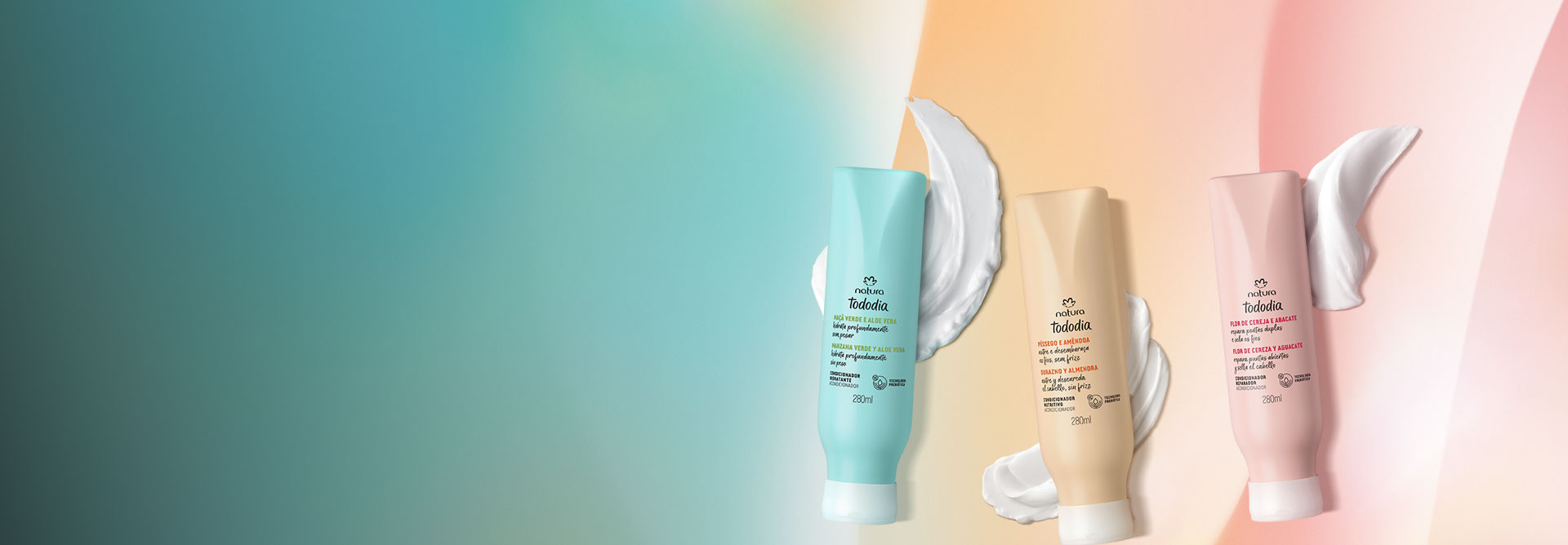 Condicionadores Natura Tododia Maçã Verde e Aloe Vera, Pêssego e Amêndoa e Flor de Cereja e Abacate, com frascos verde, amarelo e rosa, destacam-se ao lado de suas texturas em fundo multicolorido.