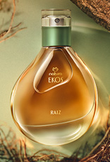Perfume Natura Ekos Raiz em fundo verde claro com madeiras, folhas e raízes.