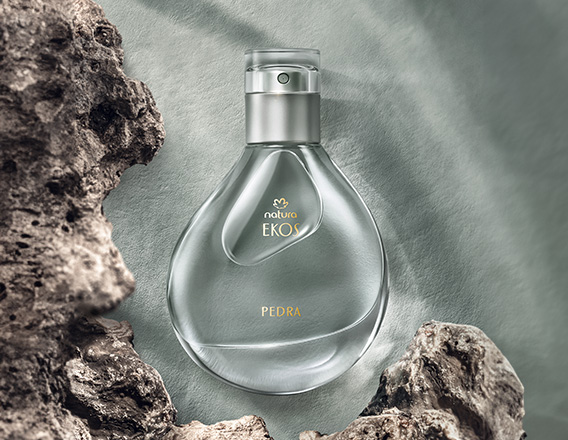 Perfume Natura Ekos Pedra em fundo cinza com pedras.