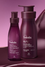 Produtos da linha Natura Tododia Cereja Negra e Praliné sobre forma orgânica na cor vinho e fundo em tons de rosa.