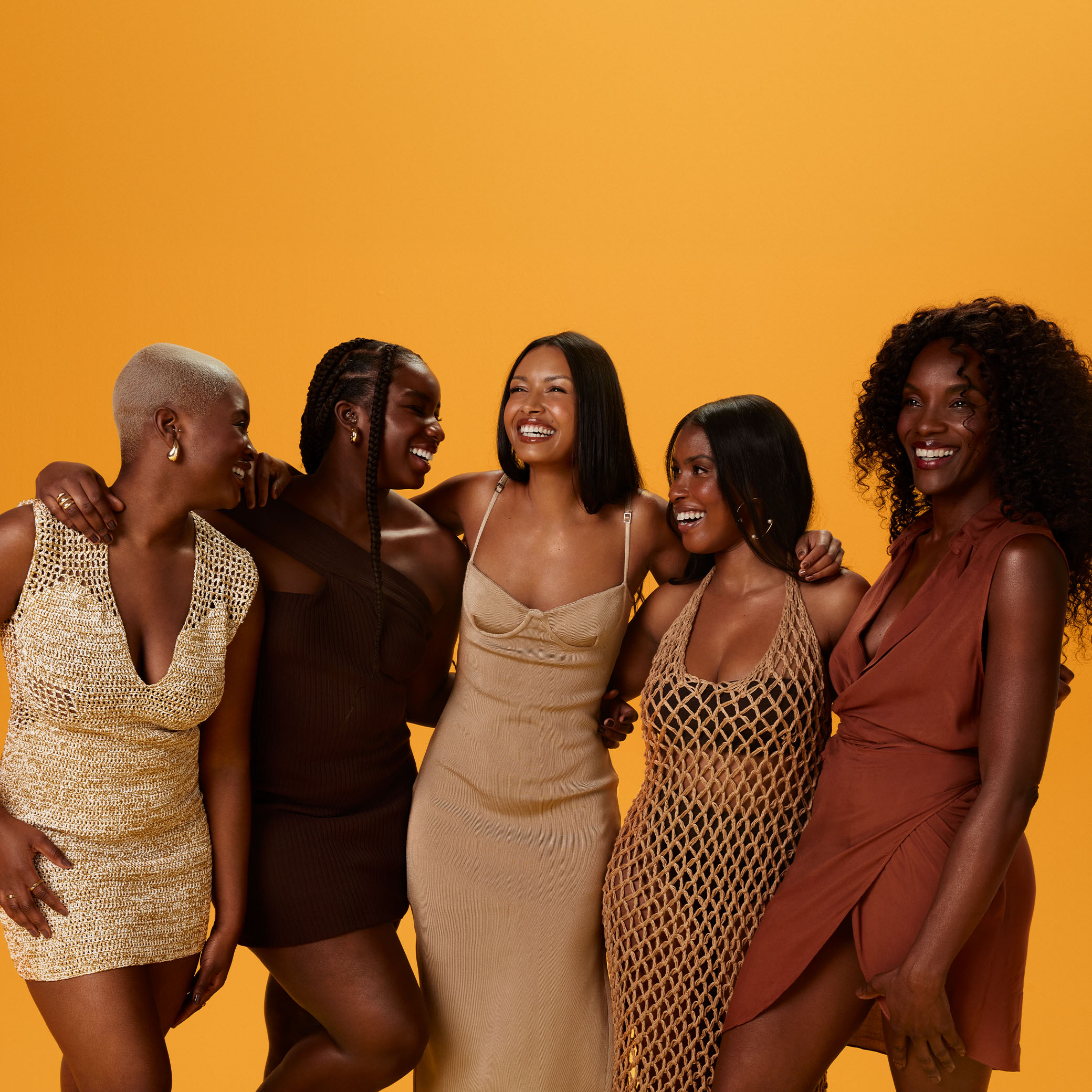 5 mulheres pretas sorridentes de biotipos diversos exibem produtos Natura Tododia em frascos e potes. Fundo amarelo vibrante.