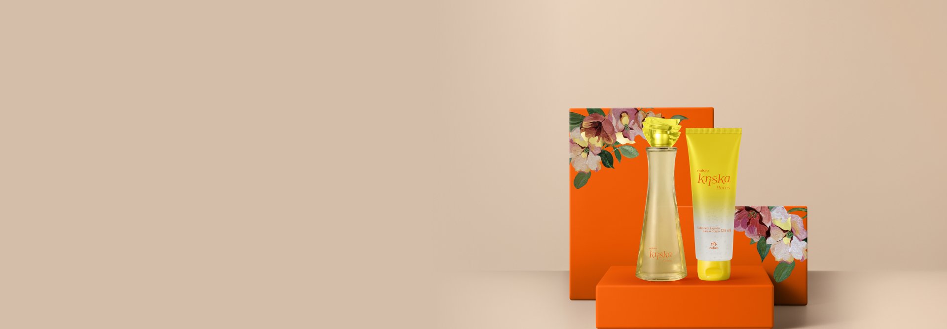 Presente Natura Kriska Flores, contendo 1 Desodorante Colônia e 1 Sabonete Líquido para o Corpo com Partículas Iluminadoras. Os itens estão sobre caixas de presentes laranja com estampa de flores.