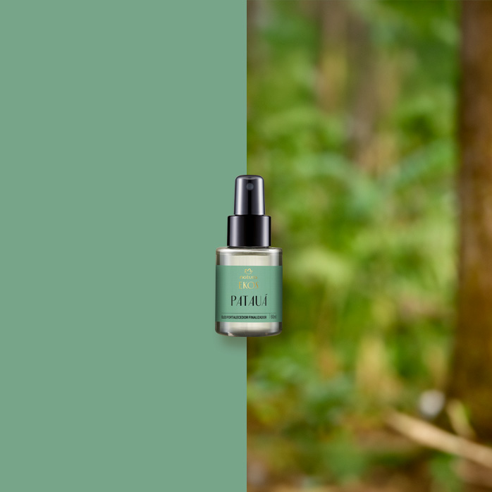 Frasco do Óleo Fortalecedor Finalizador Ekos Patauá com rótulo verde e tampa preta está centralizado, dividido entre fundo verde sólido e floresta desfocada ao fundo.