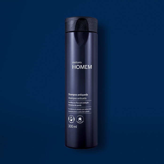 Novo Shampoo Antiqueda Natura Homem aparece em destaque no centro da tela sobre fundo azul-marinho.