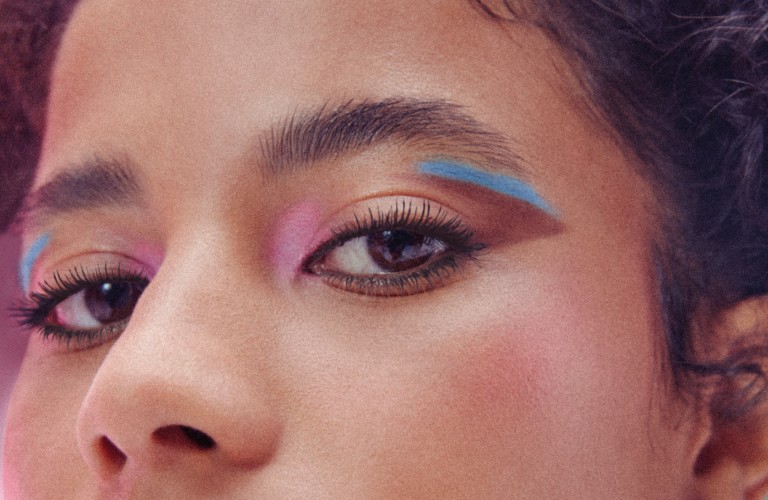 moça de batom marrom e delineado colorido gráfico nos olhos