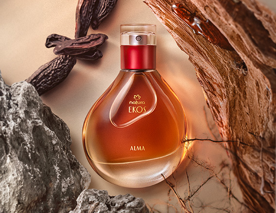 Perfume Natura Ekos Alma em fundo em tom de creme com pedras, madeiras, raízes e sementes.
