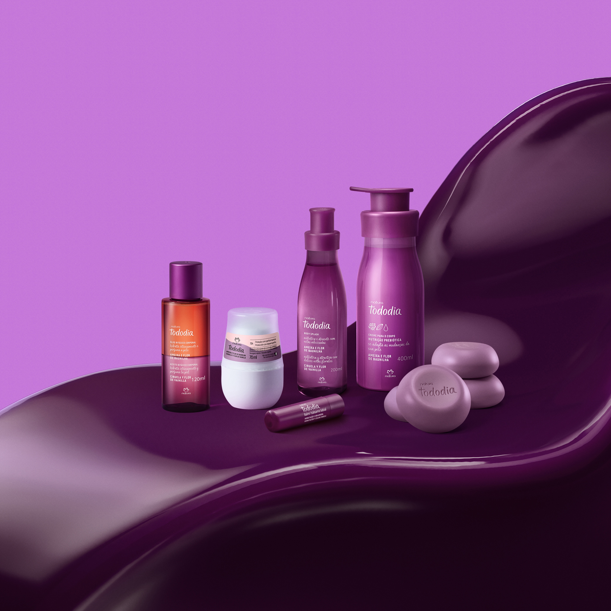 Fundo roxo. Em destaque 6 produtos de Tododia Ameixa e Flor de Baunilha, incluindo óleo, desodorante, batom, fragrância, creme e sabonetes sobre uma textura cremosa na cor roxa.