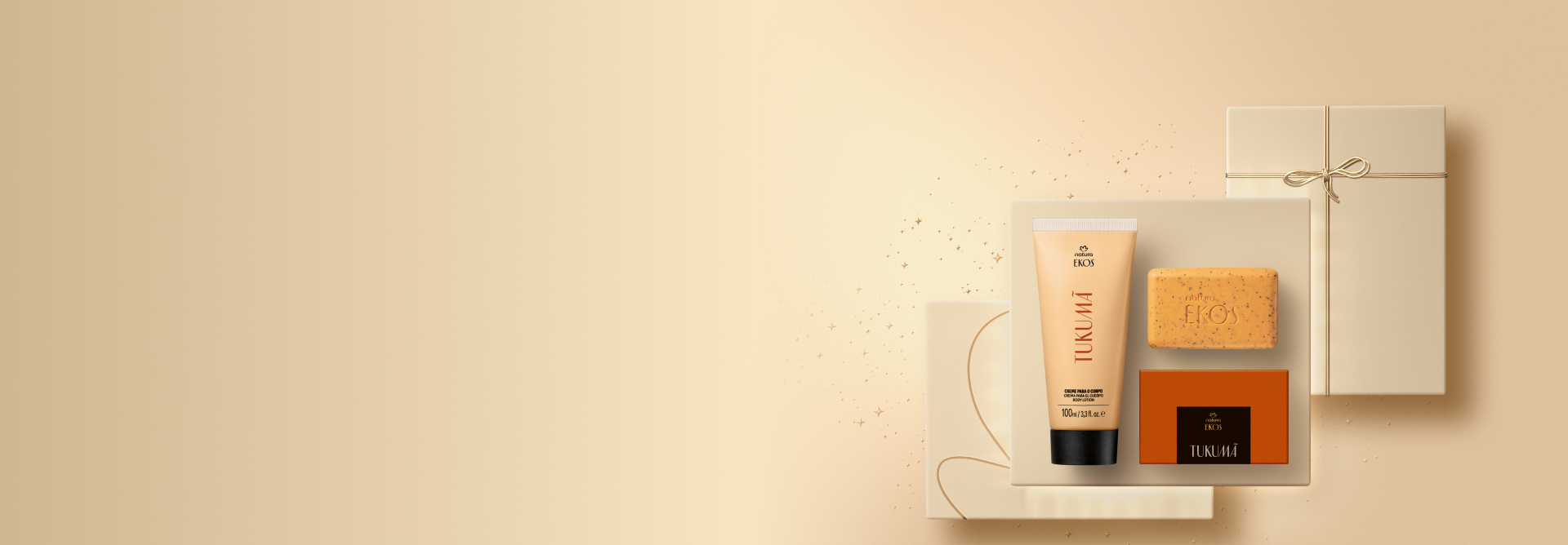 Presente Natura Ekos Tukumã, incluindo 1 Creme para o Corpo e 1 Sabonete em Barra Esfoliante sobre caixas de presentes douradas e fundo bege-claro.